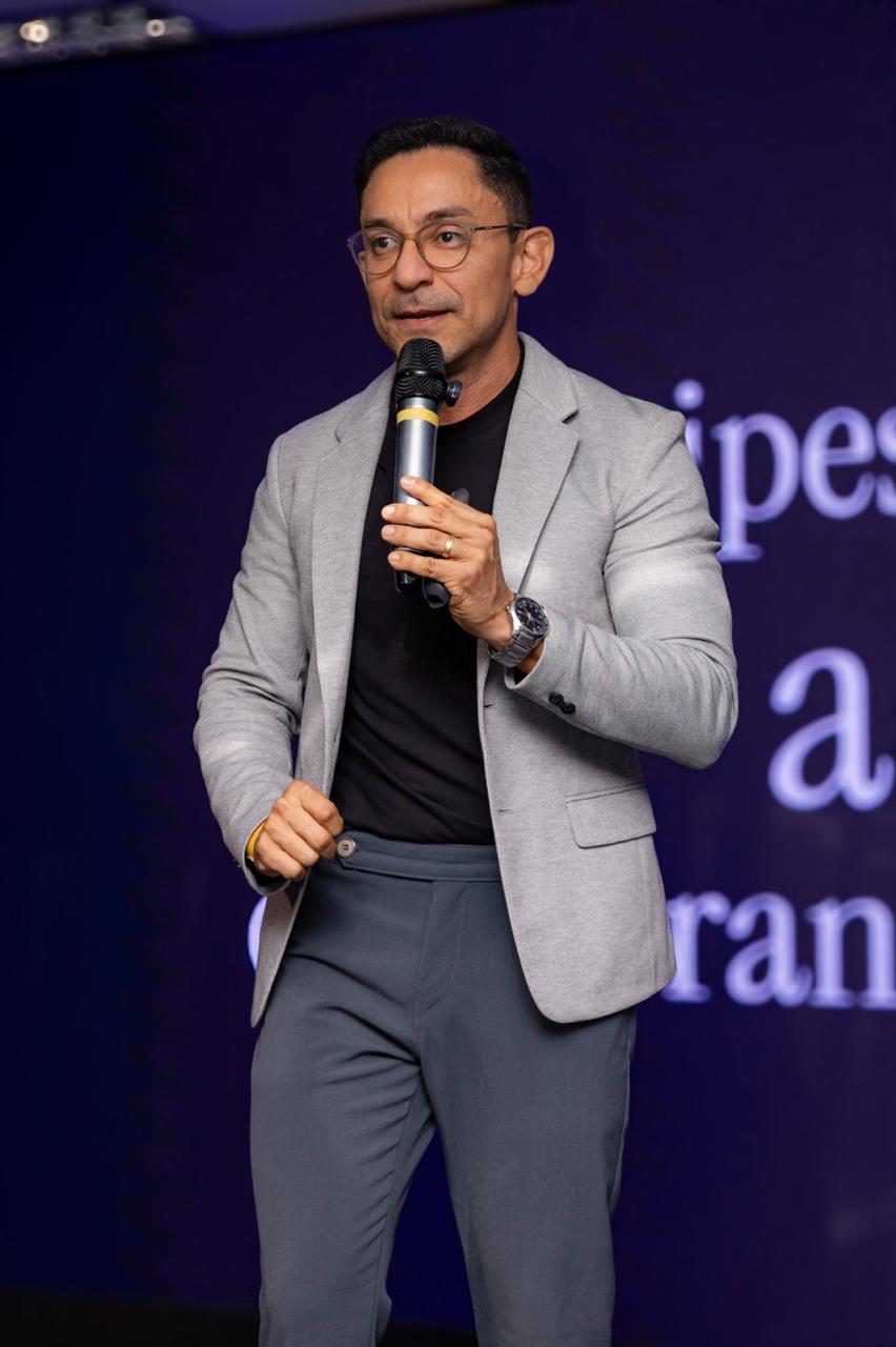 Marcelo Pereira falando ao microfone em um evento